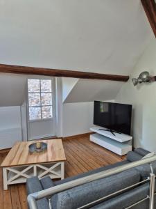 a living room with a tv and a table at Gite independant Chateau-Renault Centre in Château-Renault +7 photos