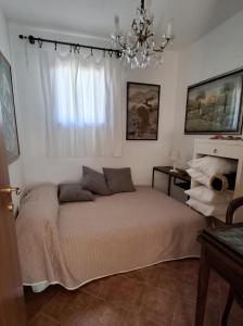 Casa Vacanze CIMMO في Tavernole sul Mella: غرفة نوم بها سرير وثريا