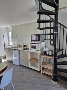 a kitchen with white appliances and a spiral staircase at Gite independant Chateau-Renault Centre in Château-Renault
