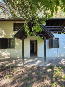 a building with a porch with a tree at SaDa Riverside in Apatin