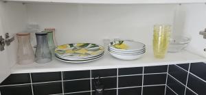 a shelf with plates and vases on it at cosy studio in Saint-Maximin-la-Sainte-Baume +2 photos