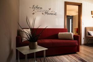 a living room with a red couch and a table at Ferienwohnung Kreidl in Schlitters