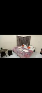 a bedroom with a bed with a table and a rug at krishna suraj villa in Chikalda