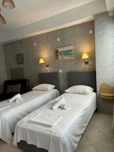 zwei Betten in einem Hotelzimmer mit weißer Bettwäsche in der Unterkunft Abeas Samos Antonis 3 in Samos