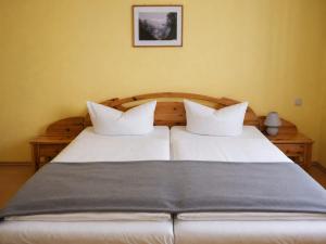 a bed with two white pillows in a bedroom at Pension NoAs in Sassnitz