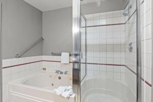 a white bathroom with a tub and a shower at Sunset Haven Oceanfront Hotel in Depoe Bay