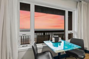 a dining room with a table and chairs and a window at Sunset Haven Oceanfront Hotel in Depoe Bay