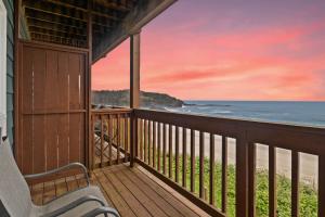 a porch with a bench looking out at the ocean at Sunset Haven Oceanfront Hotel in Depoe Bay