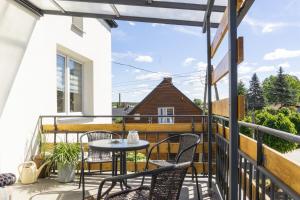 a patio with a table and chairs on a balcony at Willa Antonina in Supraśl