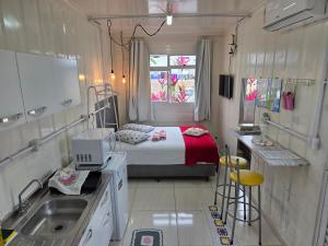 a small room with a bed and a sink in it at Espaço Container Itapema - Loft I in Itapema