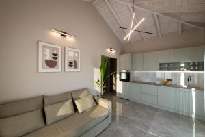 ein Wohnzimmer mit Sofa und eine Küche in der Unterkunft Koroni Poolside Suites in Koroni