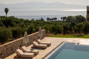 Eine Villa mit Pool und Meerblick in der Unterkunft Koroni Poolside Suites in Koroni