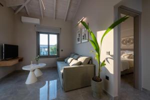 ein Wohnzimmer mit Sofa und Bett in der Unterkunft Koroni Poolside Suites in Koroni