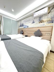 two beds in a room with a wall mural at 枳兮酒店 渝中区解放碑 in Chongqing +27 photos