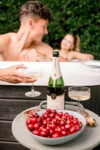 a bottle of wine and a plate of cherries next to a bath tub at Somlove in Doba +17 photos
