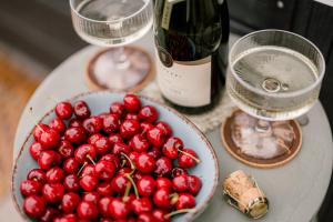 a plate of cherries on a table with a bottle of wine at Somlove in Doba