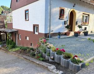 a garden in front of a house with flowers at Ferienwohnung Otterberg in Otterberg