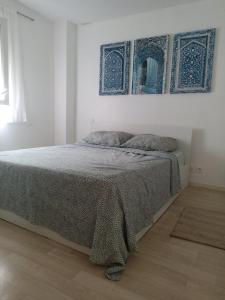 a white bedroom with a bed with a blanket on it at maison Labenne in Labenne