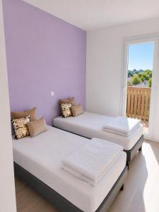 two beds in a room with a window at maison Labenne in Labenne