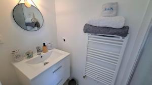 a bathroom with a sink and a mirror and towels at Chambre d'hôtes Nova, petit déjeuner en supplément 5 euros par personne in Saint-Pair-sur-Mer
