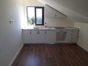 an empty kitchen with a sink and a window at Holiday Apartment in Draç