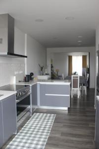 a kitchen with white appliances and a dining room at Casa do Tempo in Achada
