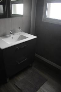 a bathroom with a white sink and a window at Casa do Tempo in Achada