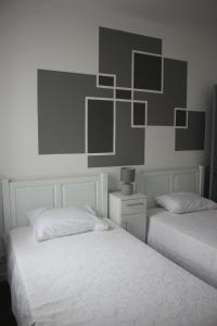 a bedroom with two beds and a painting on the wall at Casa do Tempo in Achada