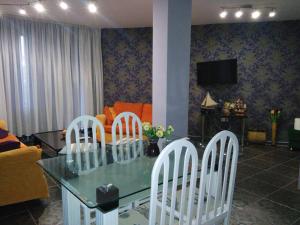 sala de estar con mesa de cristal y sillas blancas en Apartments Vicente, en Golden Sands
