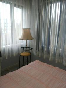 1 dormitorio con 1 cama, 1 silla y 1 lámpara en Apartments Vicente, en Golden Sands