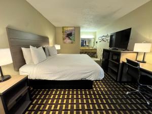 a hotel room with a bed and a flat screen tv at Travelodge by Wyndham Thomasville AL in Thomasville