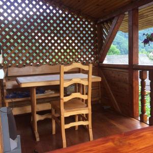 a wooden table and chair in a gazebo at Садиба Хатинка у Люби in Yaremche