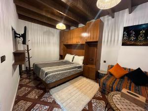 a bedroom with a bed and a couch at Studio ALADIN in Rabat