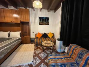 a room with a bed and a couch and a table at Studio ALADIN in Rabat