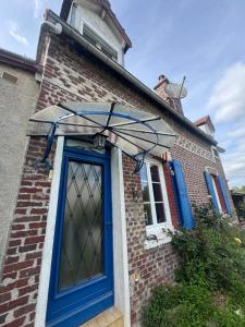 a blue door on a brick house with a roof at Gîte de campagne in Candor