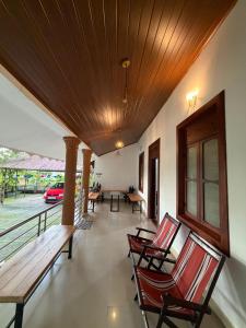 a porch with chairs and a wooden ceiling at Koyiloth house by intertrip in Kalpetta