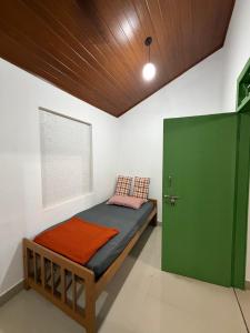 a bed in a room with a green door at Koyiloth house by intertrip in Kalpetta
