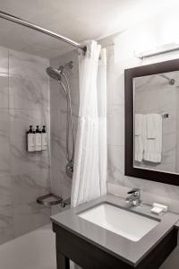 a white bathroom with a sink and a shower at Ottawa Embassy Hotel & Suites in Ottawa +35 photos