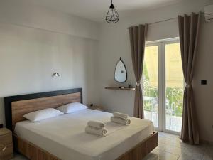 a bedroom with a bed with two towels on it at Riverside Rooms Ammoudia in Ammoudia