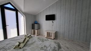 a bedroom with a bed and a tv on the wall at ZemZemHotel in Zaqatala