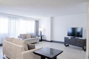 a living room with a couch and a tv at Ottawa Embassy Hotel & Suites in Ottawa