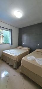 a room with two beds and a window at Hospedaria Mandassaia in Lençóis