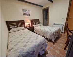a bedroom with two beds and a table with a lamp at Casa Mariana in Lubián +34 photos