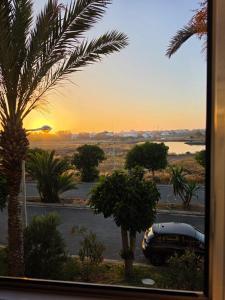 a view of a car parked in a parking lot with a sunset at Spacious apartment, pool, beach, basement parking in Bouznika