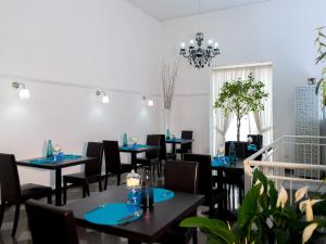 a dining room with tables and chairs and a chandelier at Hotel Santa Chiara in Nocera Inferiore