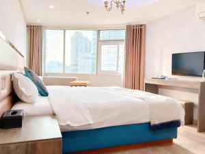 a hotel room with a large bed and a tv at 枳兮酒店 渝中区解放碑 in Chongqing