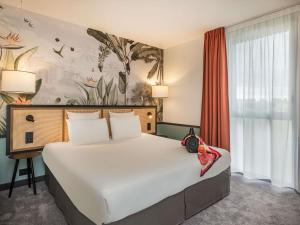 a bedroom with a large bed and a large window at Mercure Le Mans Batignolles - Hotel & Spa in Le Mans