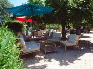 a group of chairs and a table with an umbrella at Mercure Brive in Ussac