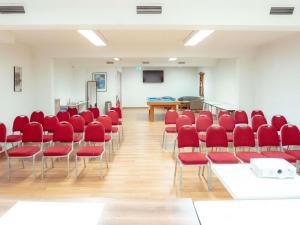 a conference room with red chairs and a screen at Mercure Brive in Ussac +82 photos