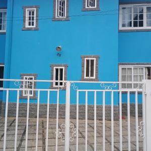 a blue building with a white fence in front of it at Apartamento 2 quartos em Conservatória - até 9 pessoas! in Conservatória